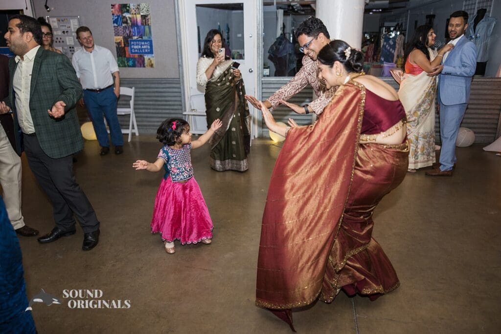 The bride and groom dancing with a little girl at their Torpedo Factory Art Center Wedding