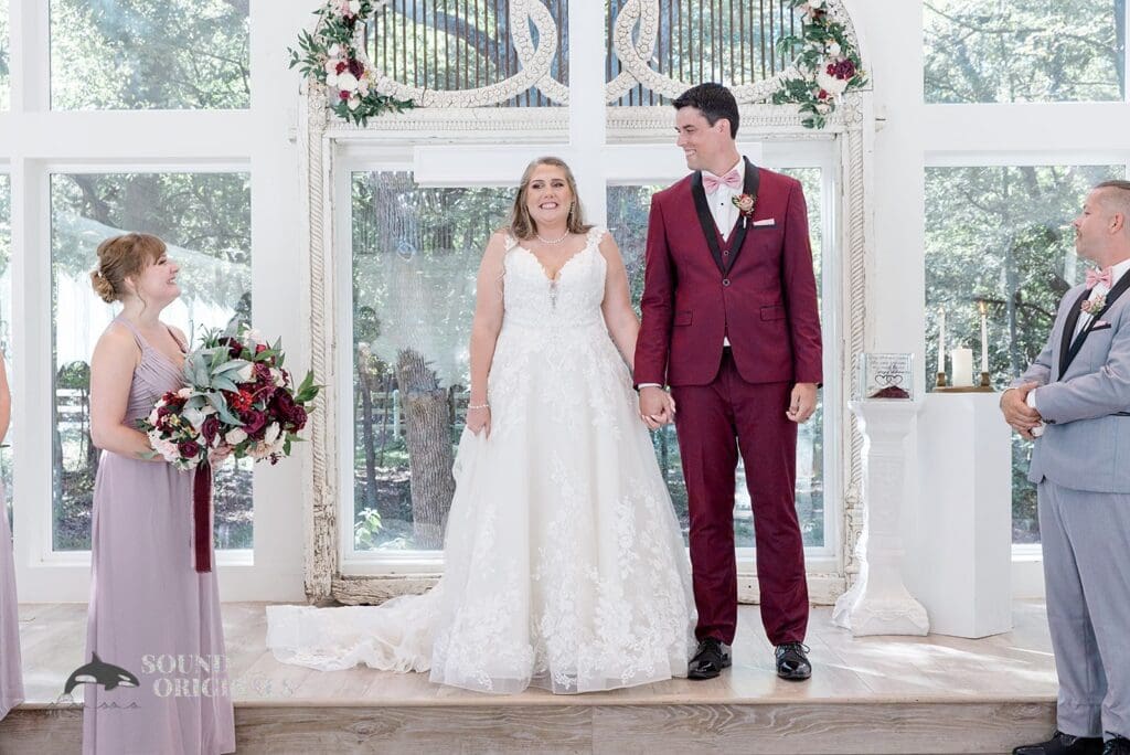 Elegant bride and groom stand beautifully in front of The French Farmhouse Wedding altar