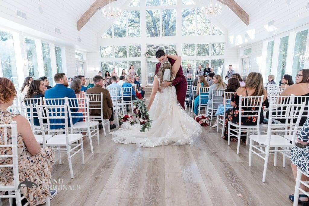 Husband and wife lock lips with a romantic kiss after a successful French Farmhouse Wedding
