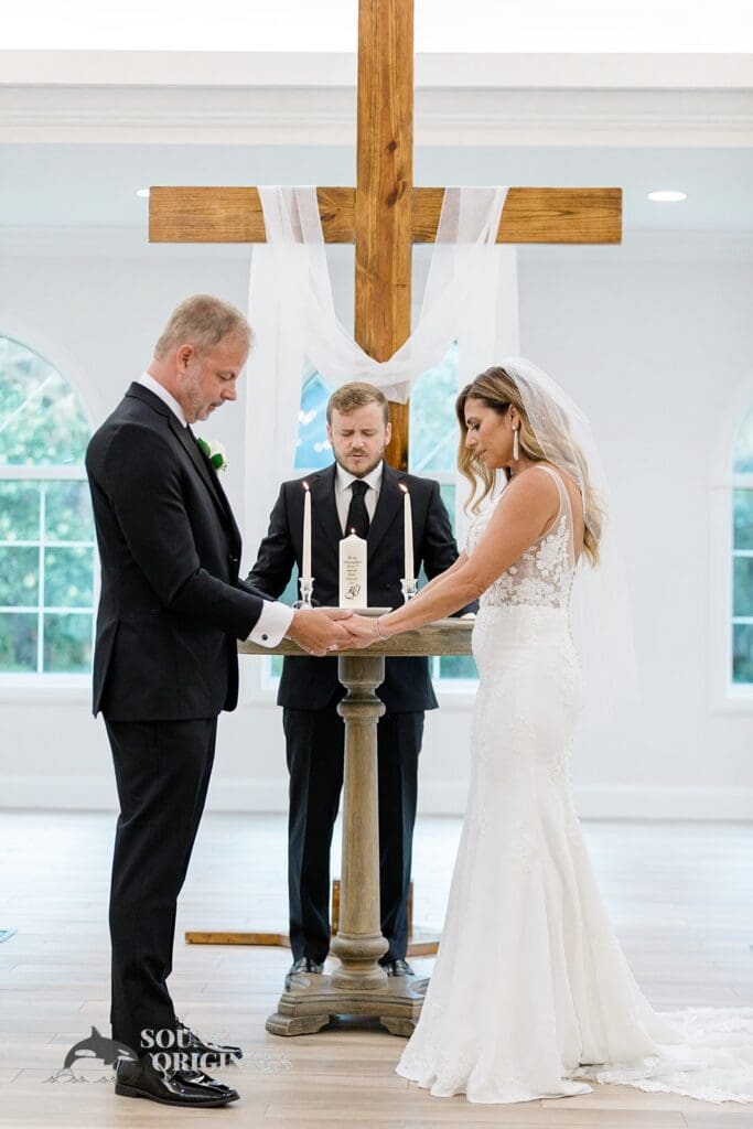Harborside Chapel Wedding Bride and groom join hands and pray during their Harborside Chapel Wedding