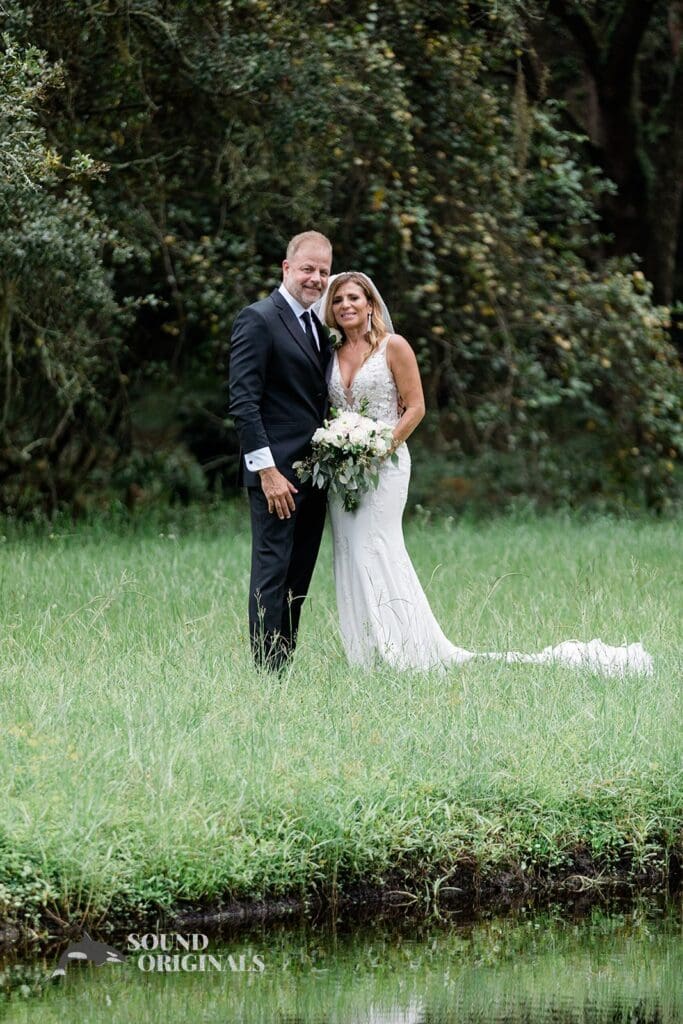 Harborside Chapel Wedding Newlyweds pose on the grassy grounds of the Harborside Chapel Wedding