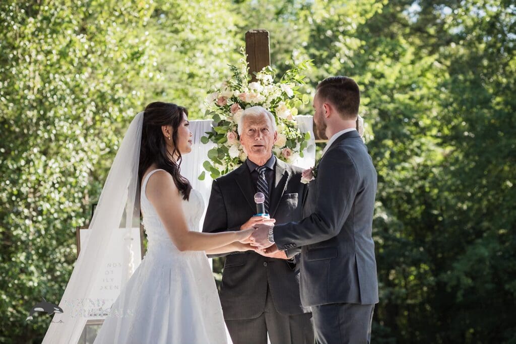 The bride and groom preparing to exchange their vows at The Oakley on the Lake Wedding