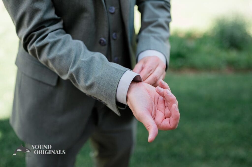 The groom buttoning his jacket for The Red Farmhouse Bed & Breakfast Wedding