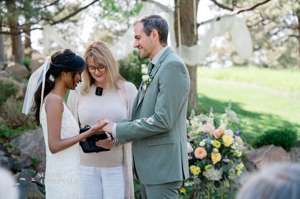 Bride and groom exchanging rings at The Red Farmhouse Bed & Breakfast Wedding