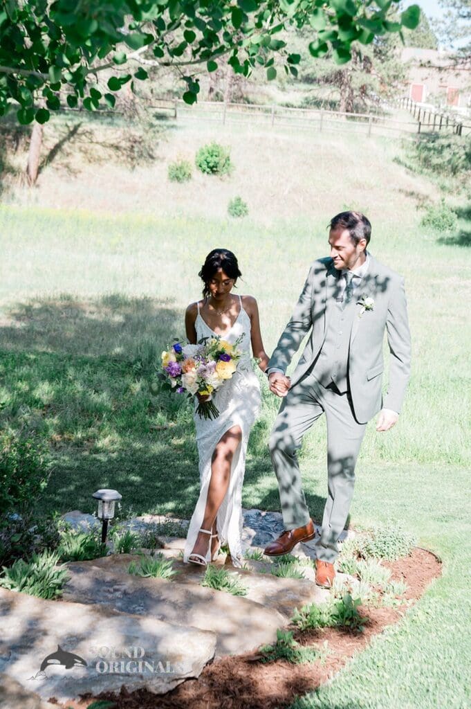 Gorgeous portrait of bride and groom walking together towards The Red Farmhouse Bed & Breakfast Wedding reception