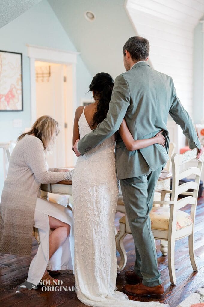 Bride and groom hugging before signing the register at The Red Farmhouse Bed & Breakfast Wedding