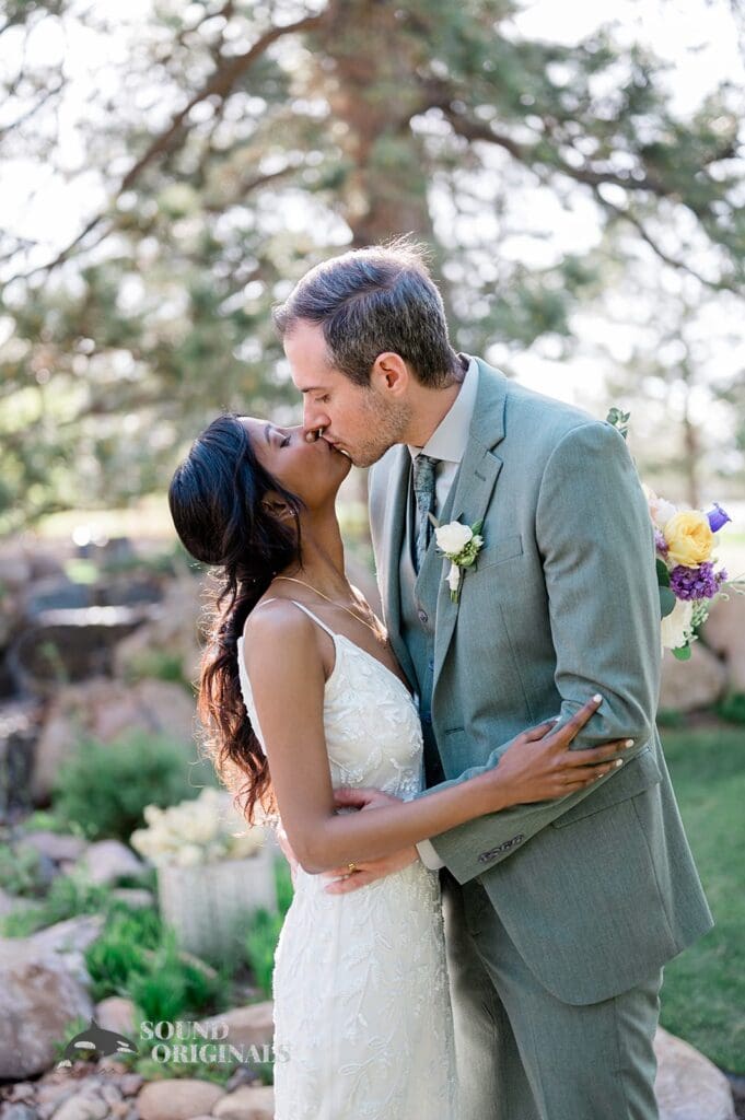 Husband and wife share a first kiss outside The Red Farmhouse Bed & Breakfast