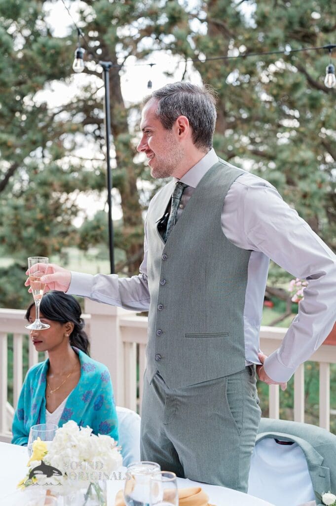The groom raises a toast at The Red Farmhouse Bed & Breakfast Wedding reception