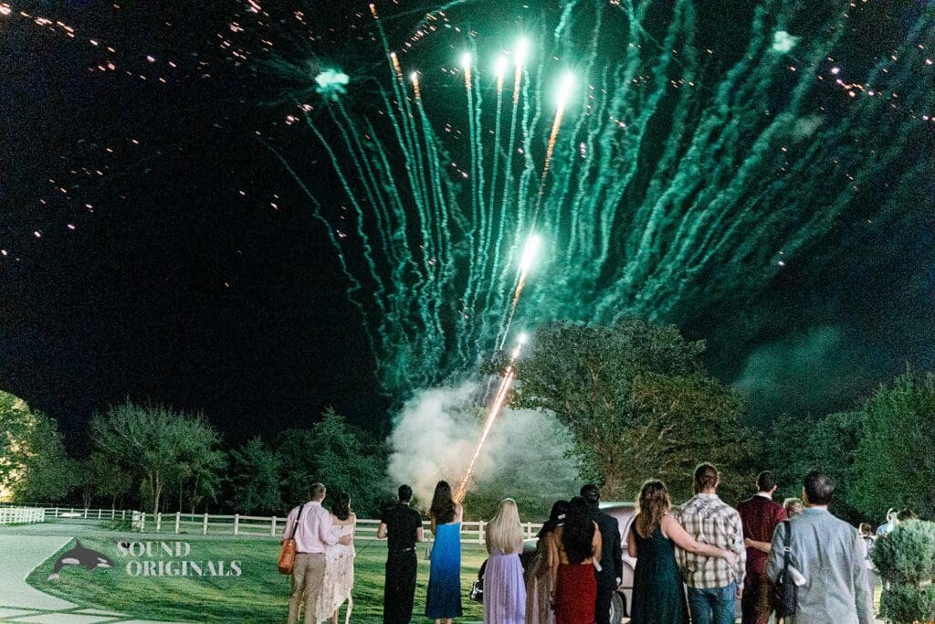 Happy French Farmhouse Wedding guests lit the atmosphere with colourful fire candles as the couple drove off the environs