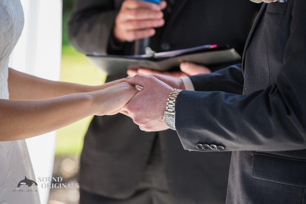 The bride and groom holding hands at the altar during The Oakley on the Lake Wedding cermony