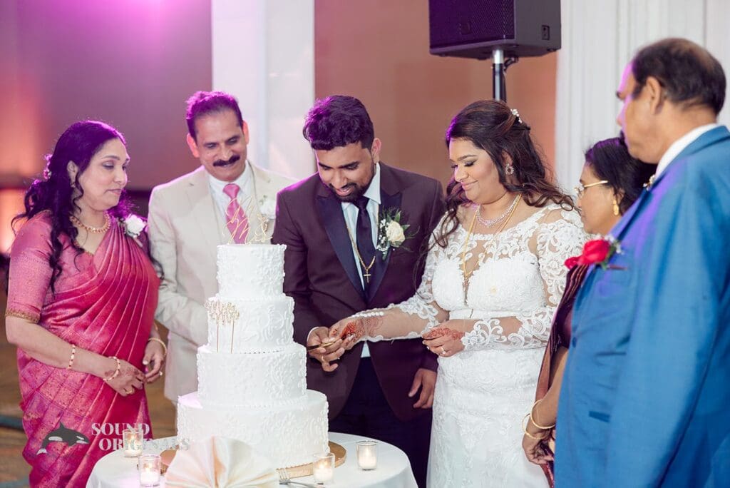 The bride and groom cut the four tier wedding cake at the Embassy Suites by Hilton Naperville Wedding