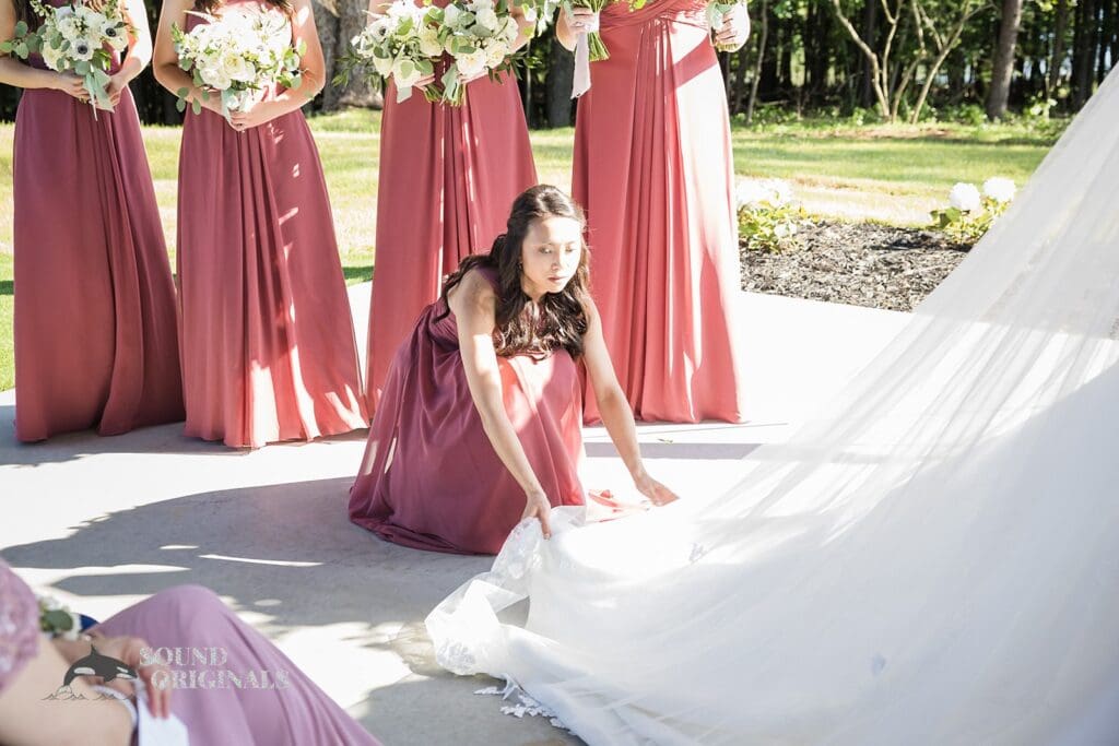 A bridesmaid correcting the train at The Oakley on the Lake Wedding