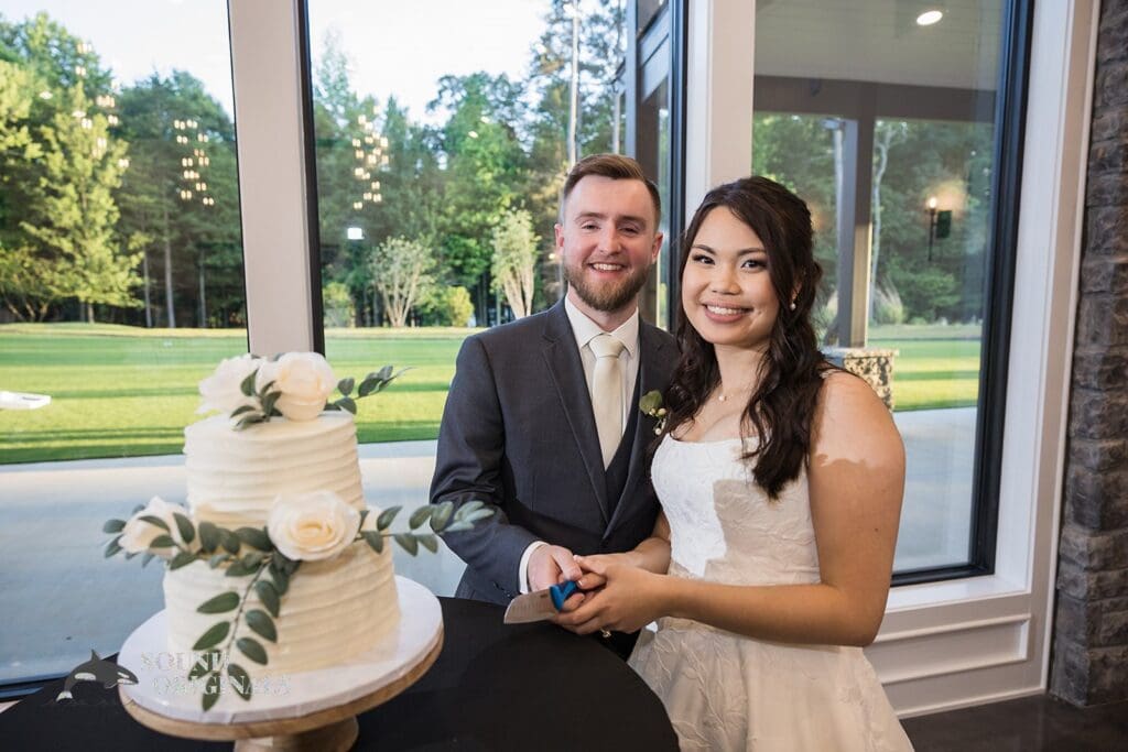 The bride and groom prepare to cut the cake at The Oakley on the Lake Wedding