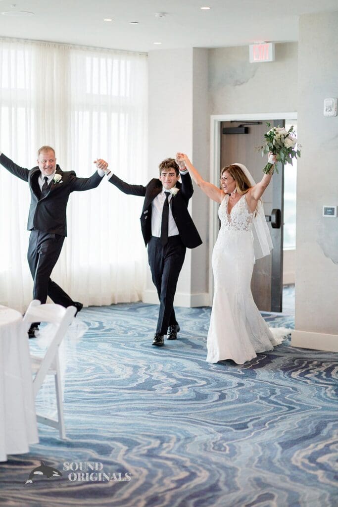 Harborside Chapel Wedding Newlyweds with significant family meber raise their arms together after the Harborside Chapel Wedding