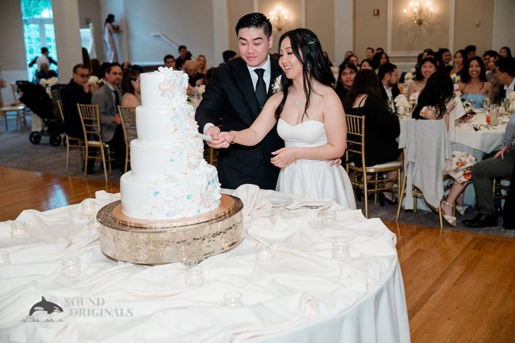 Bride and groom cut the cake at The Abbington Distinctive Banquets Wedding