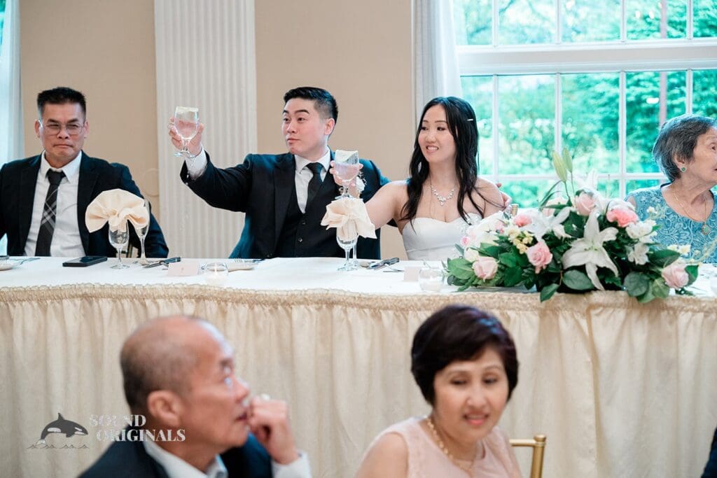 The bride and groom raising a glass at The Abbington Distinctive Banquets Wedding