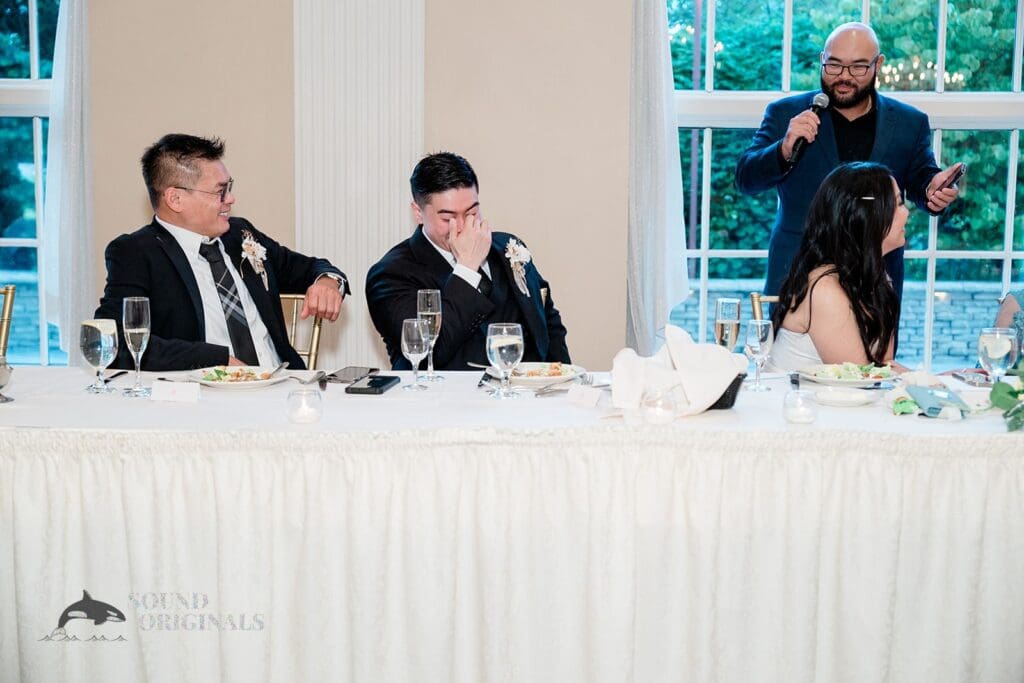 Bride and groom reacting to speeches at The Abbington Distinctive Banquets Wedding