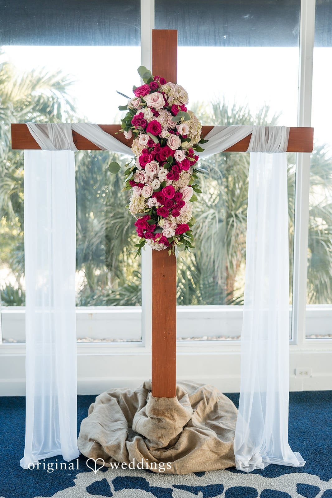 Ramon + Alexandra Beautiful wedding ceremony backdrop with wooden cross and floral arrangement