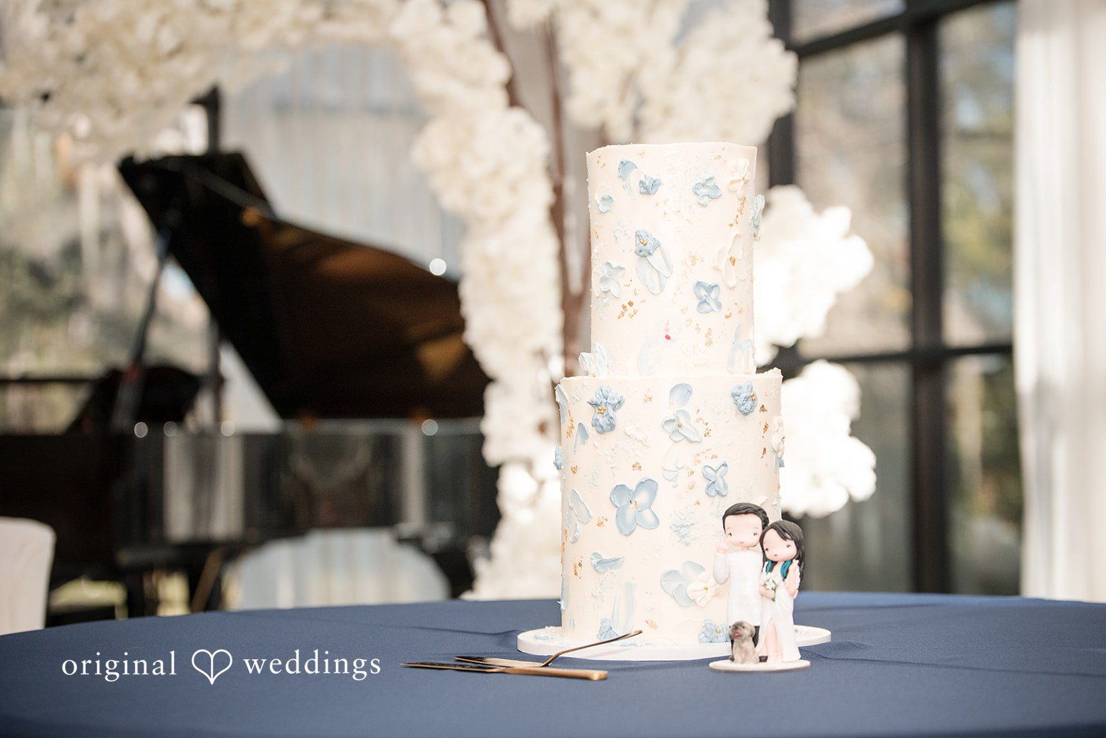 Andrea Edna + Canh White Wedding cake with blue floral decoration.