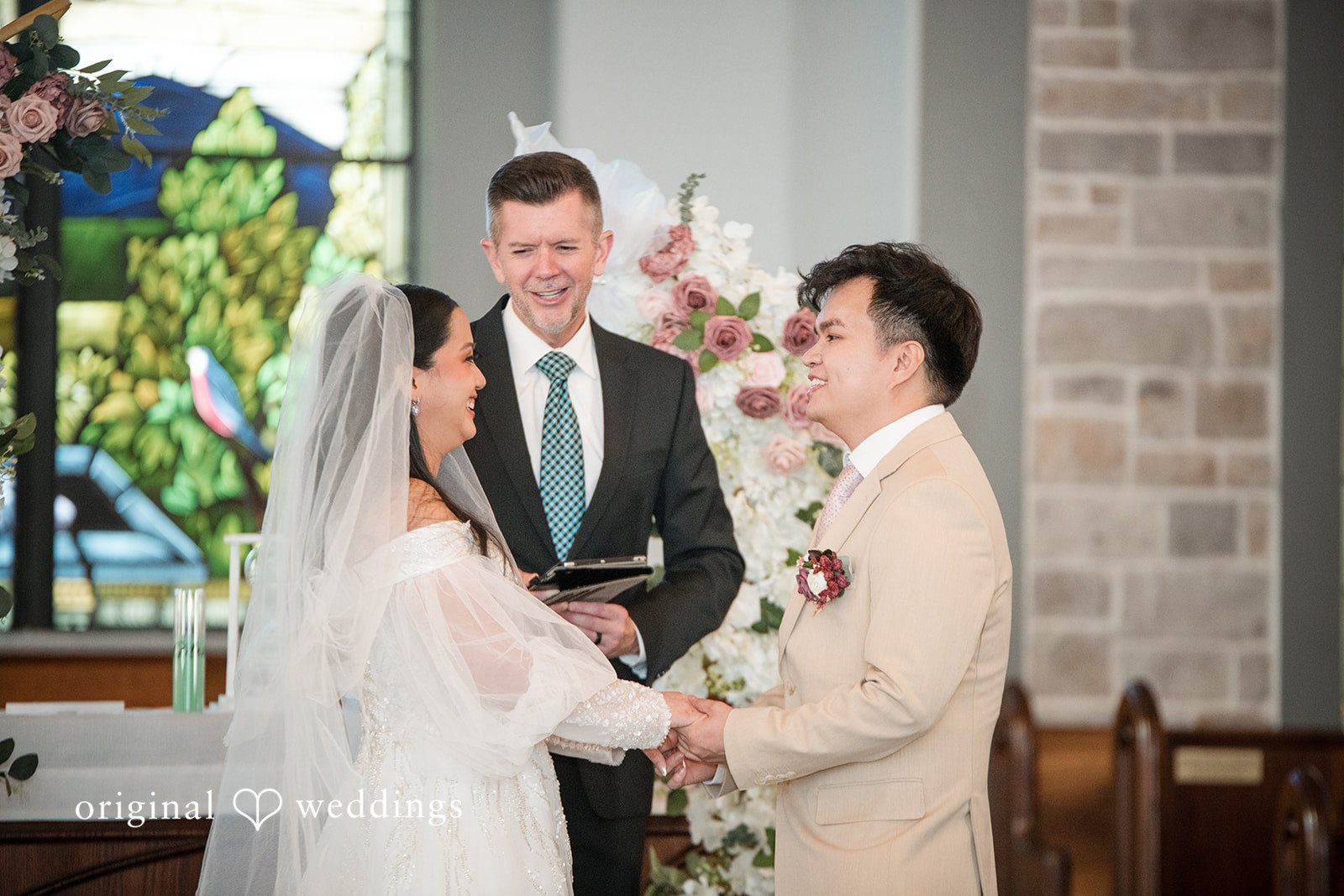 Andrea Edna + Canh Couple holding hands during ceremony.