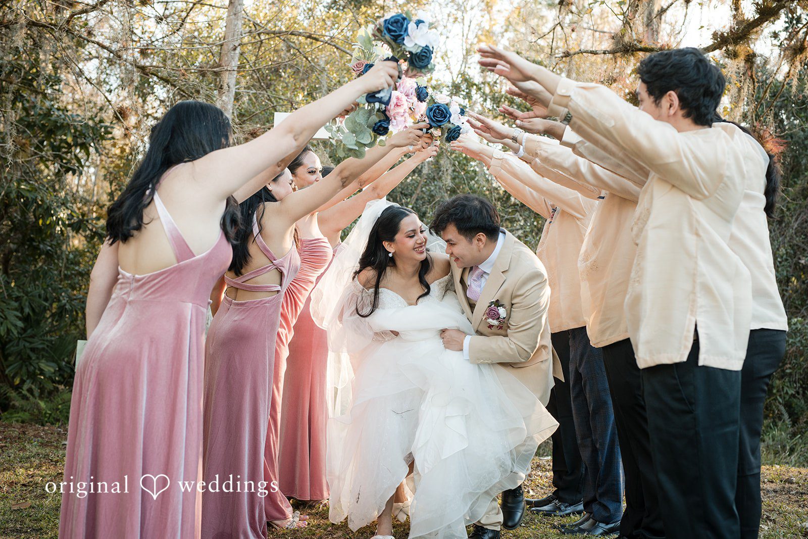 Andrea Edna + Canh Group photo of bridesmaids cheering with a bride and groom in wedding attire at Canterbury Hall Tampa