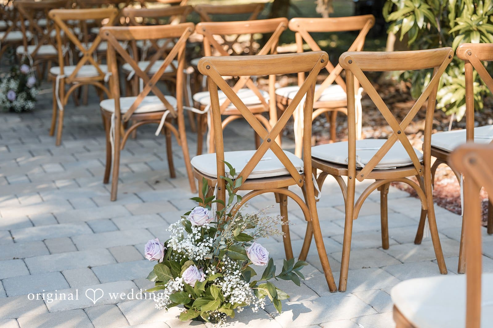 Ceremony chairs with greenery.