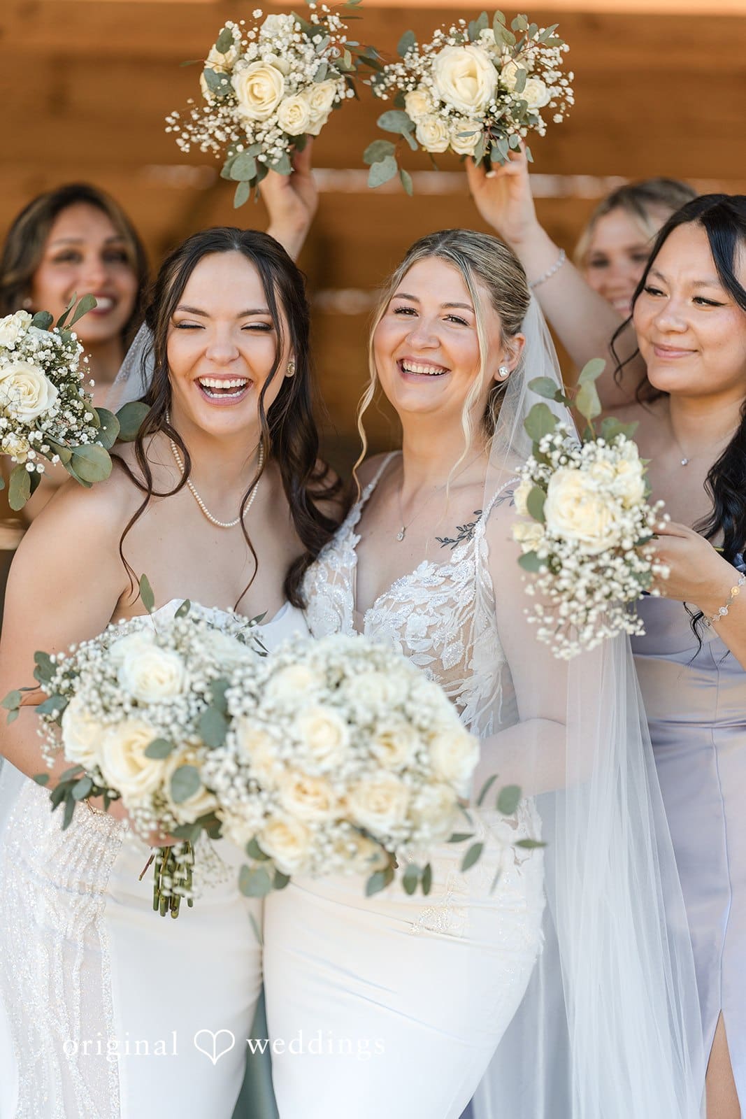 Brides with bridesmaids holding bouquets at a wedding.