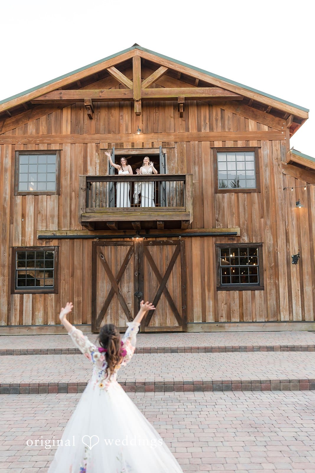 Wedding couple standing outside a wooden barn.