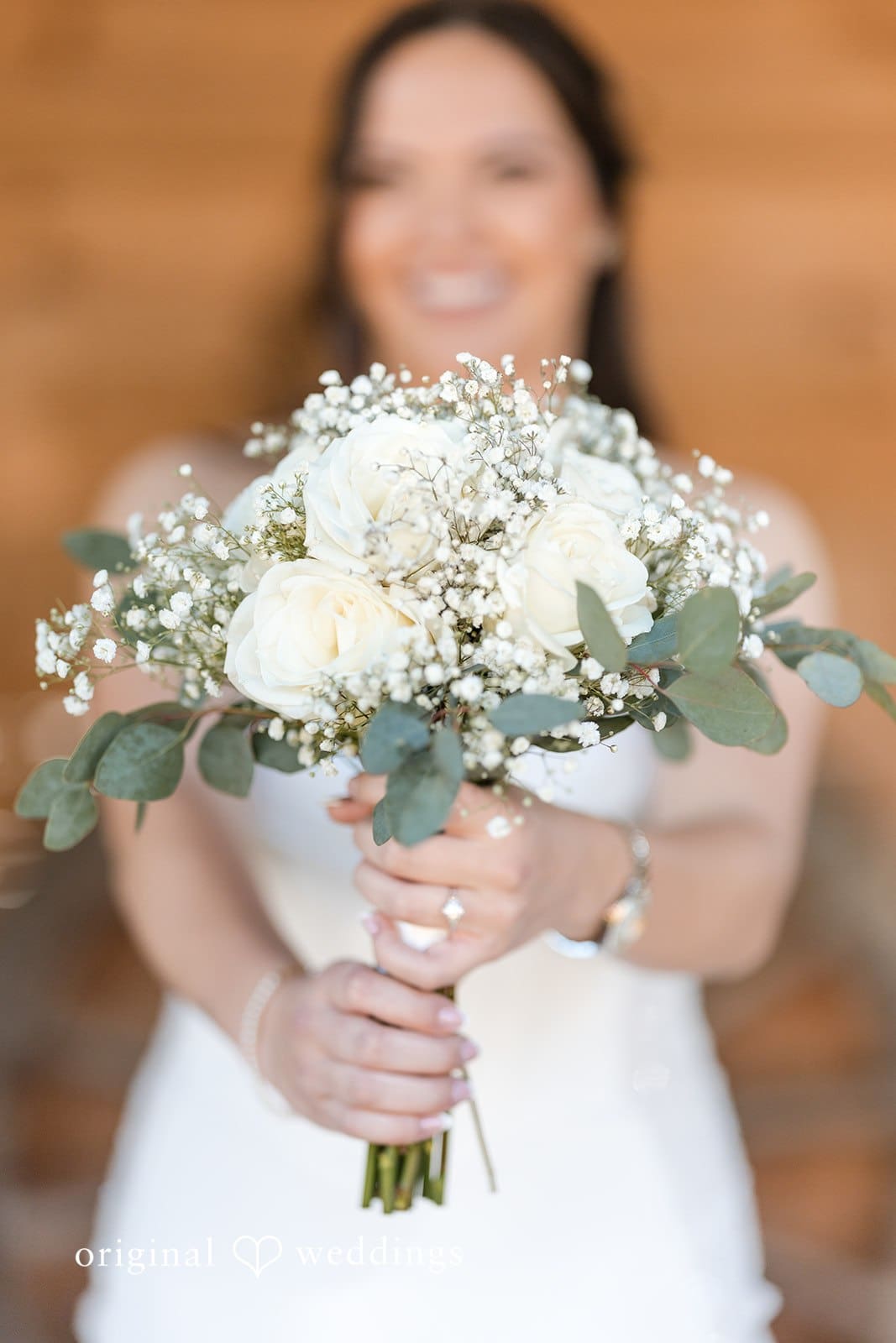 Bride holding a bouquet of white flowers.