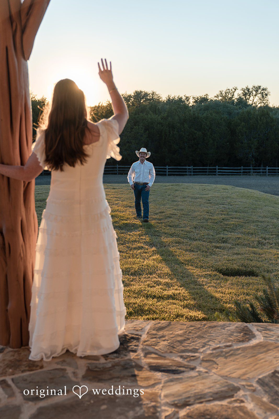 The bride walks toward her partner across a sunlit field full of anticipation.