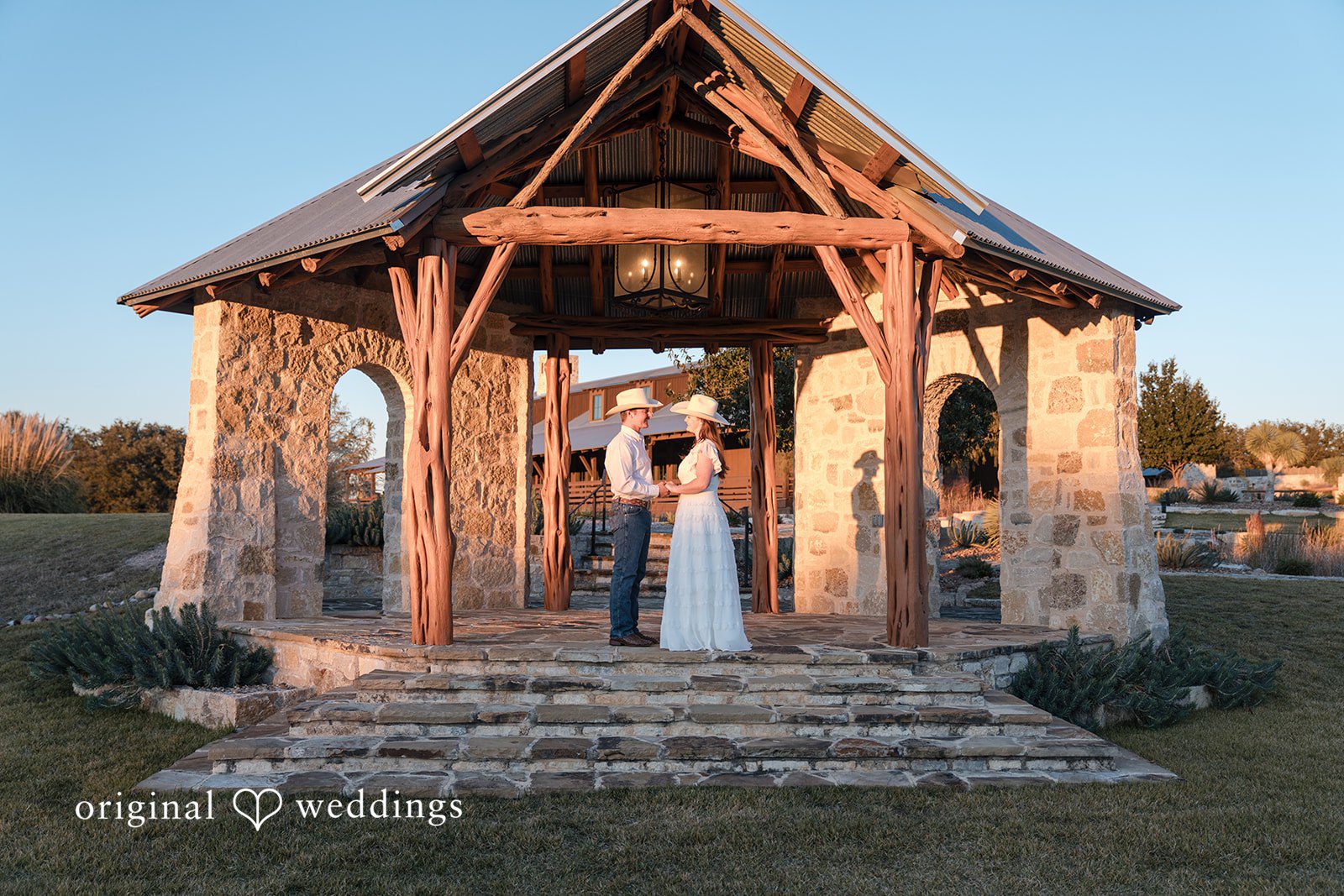 A rustic gazebo frames their love in a picturesque setting.