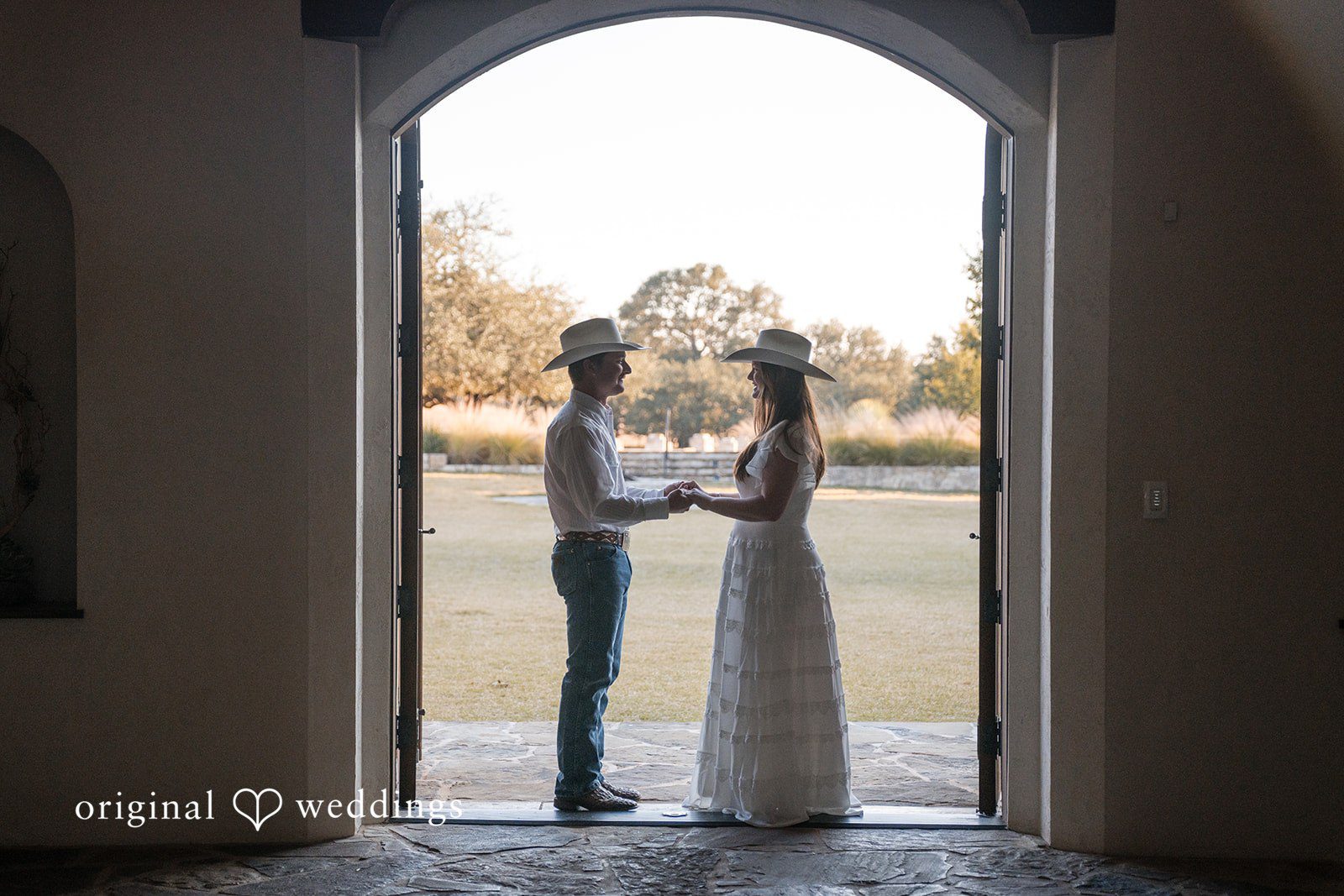 Framed by an arch, they hold hands in a perfectly balanced composition.