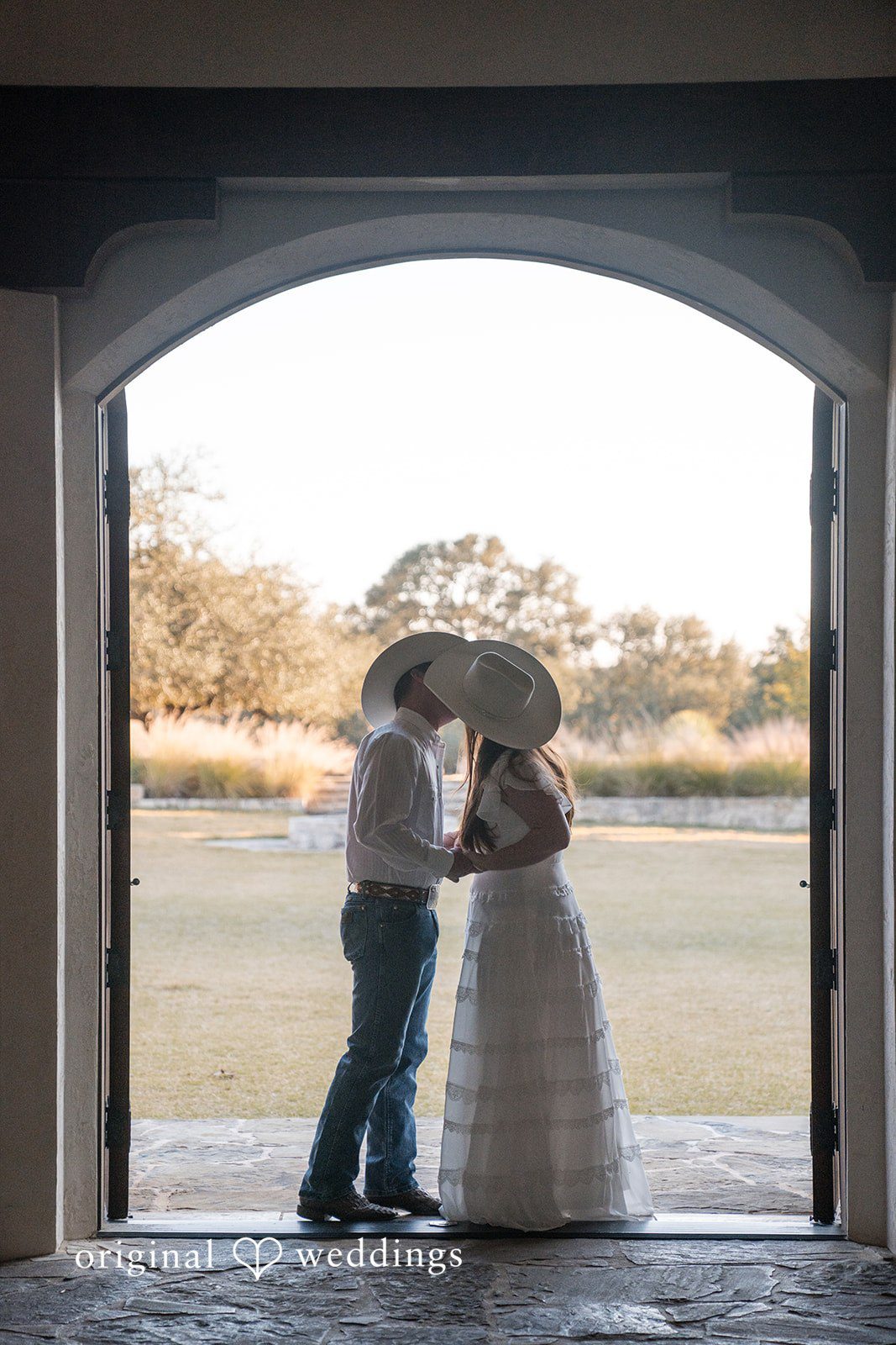 Framed by an archway, the couple shares a quiet and intimate embrace captured by austin wedding photographers.