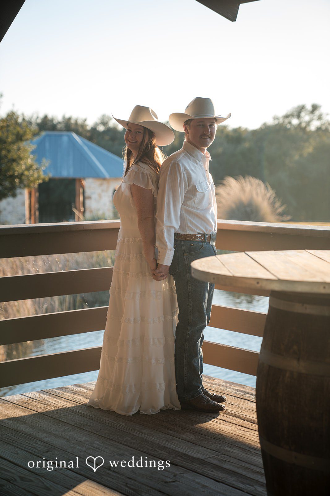 Leaning together on a wooden fence, they share a relaxed, loving moment.