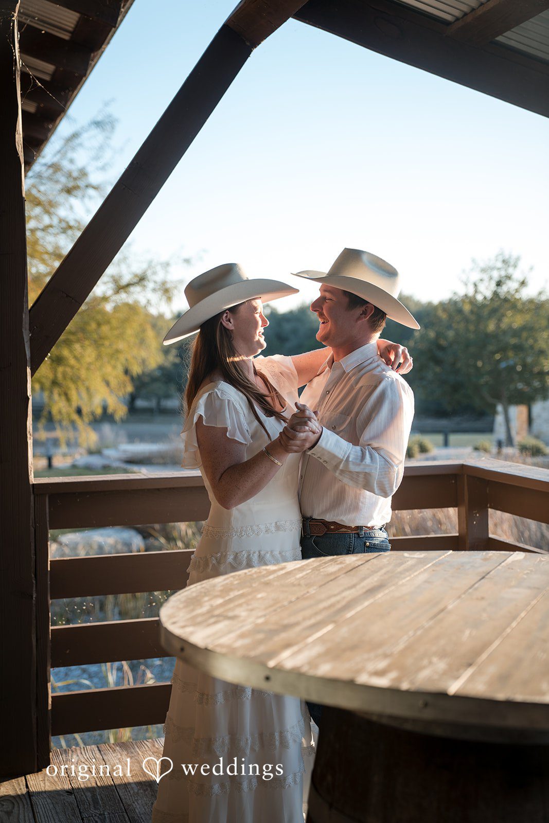 A tender kiss captured in warm, golden light on a wooden terrace.