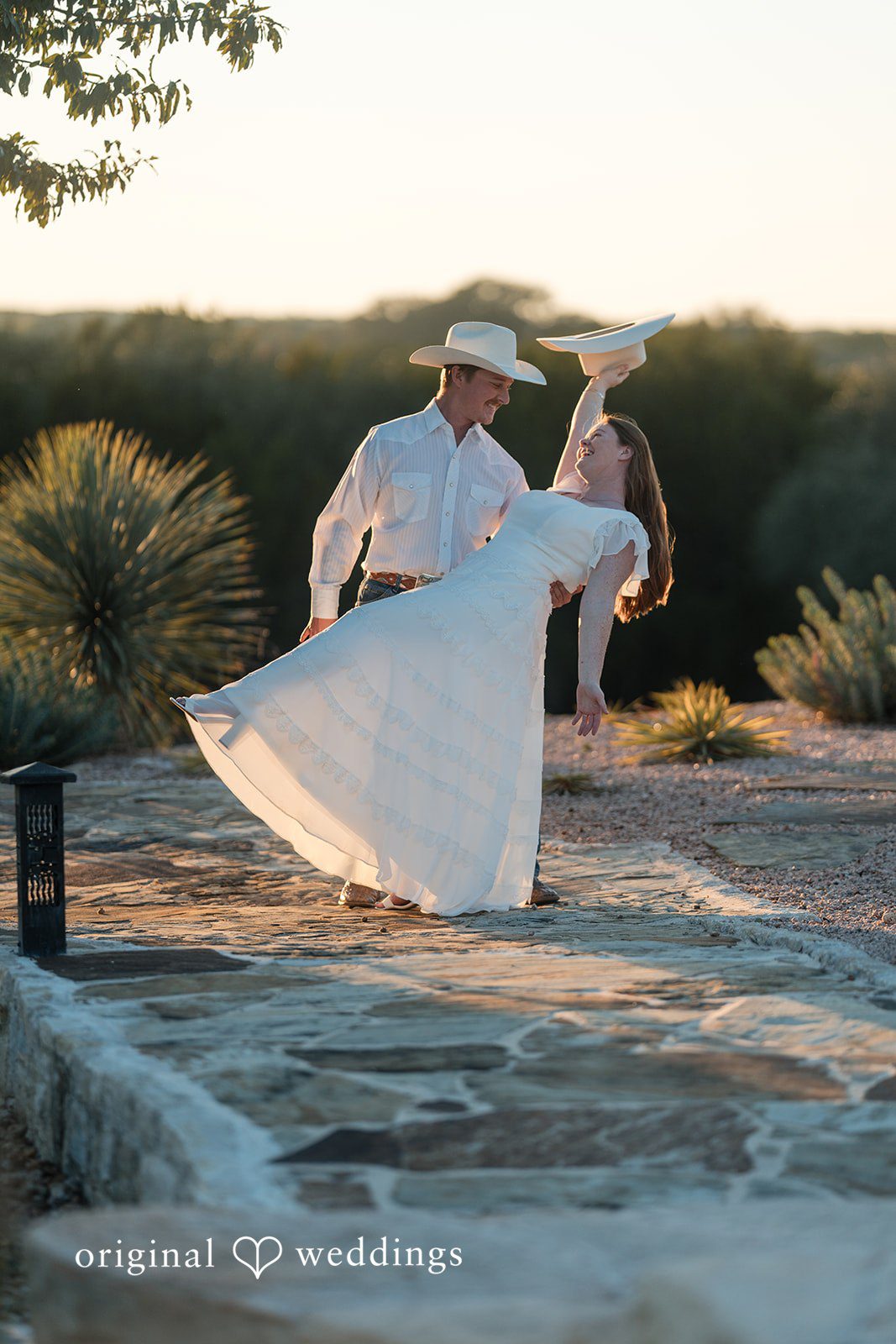 The bride’s dress flows beautifully as they spin together outdoors.