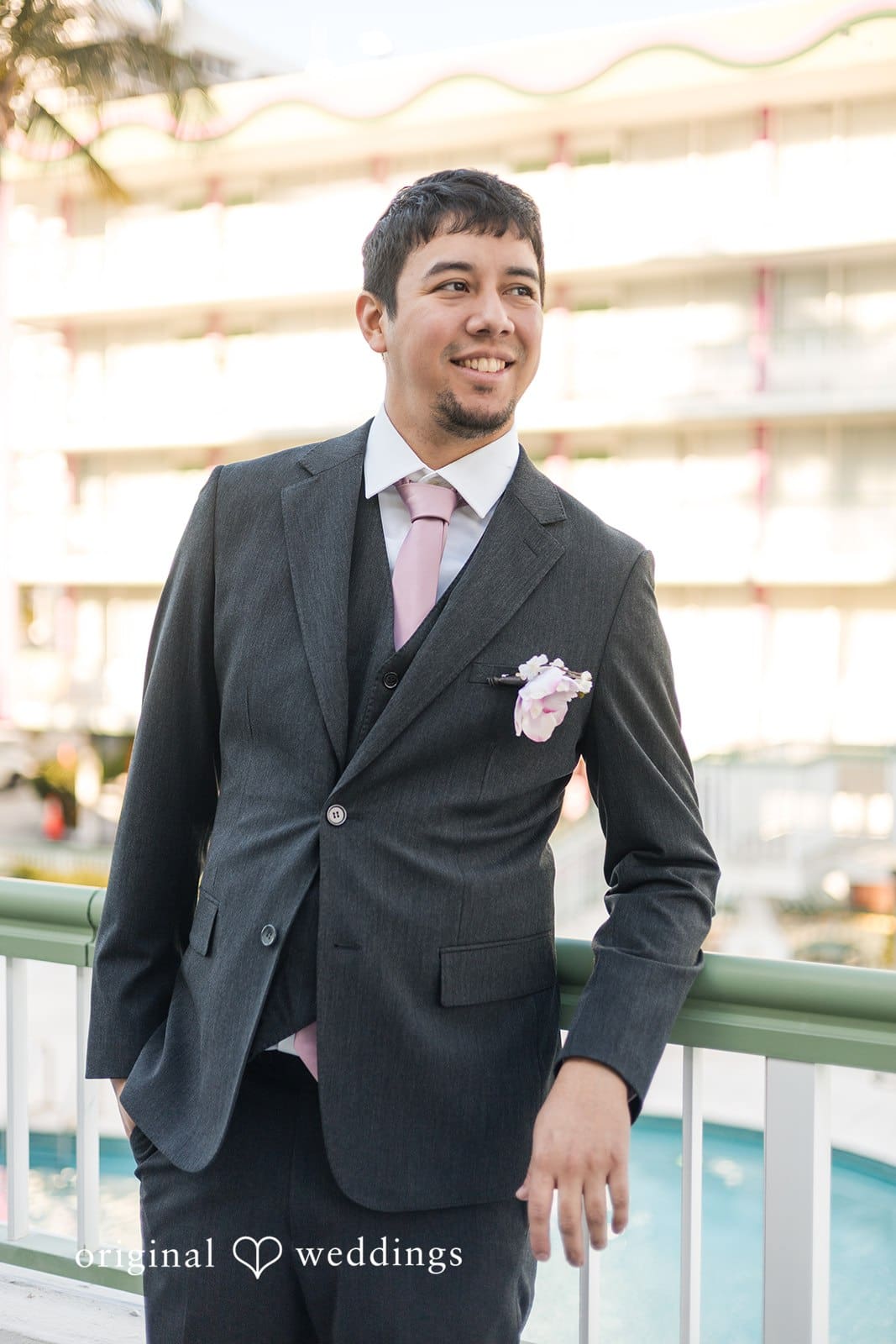 Groom posing in suit outdoors.