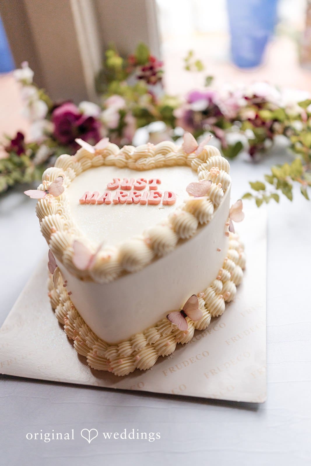 Heart-shaped wedding cake decorated with pink and white icing.
