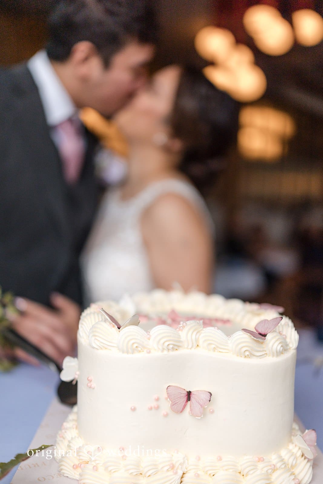 Bride and Groom cutting a white wedding cake.