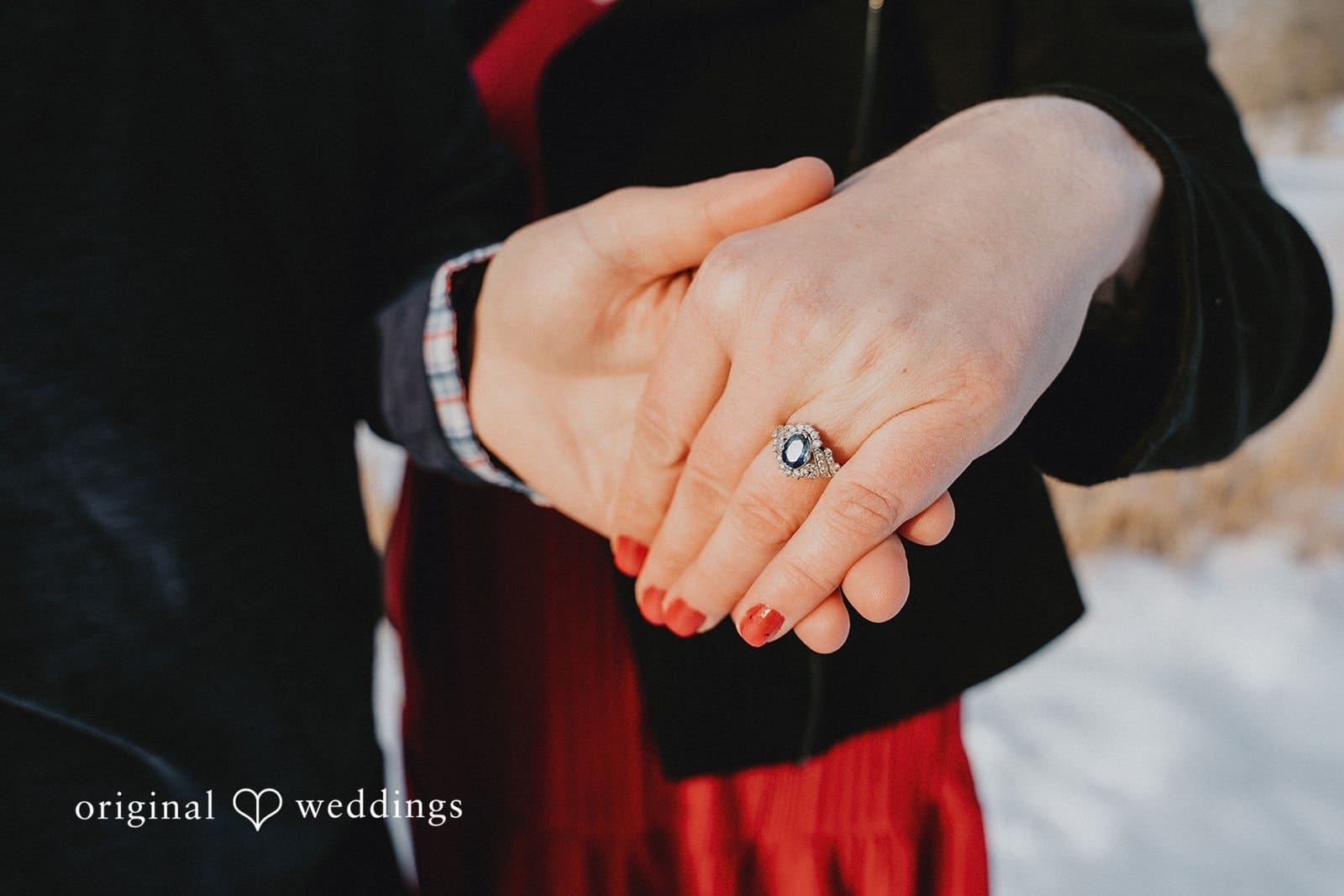 A close-up shot of the couple's hands and the engagement ring