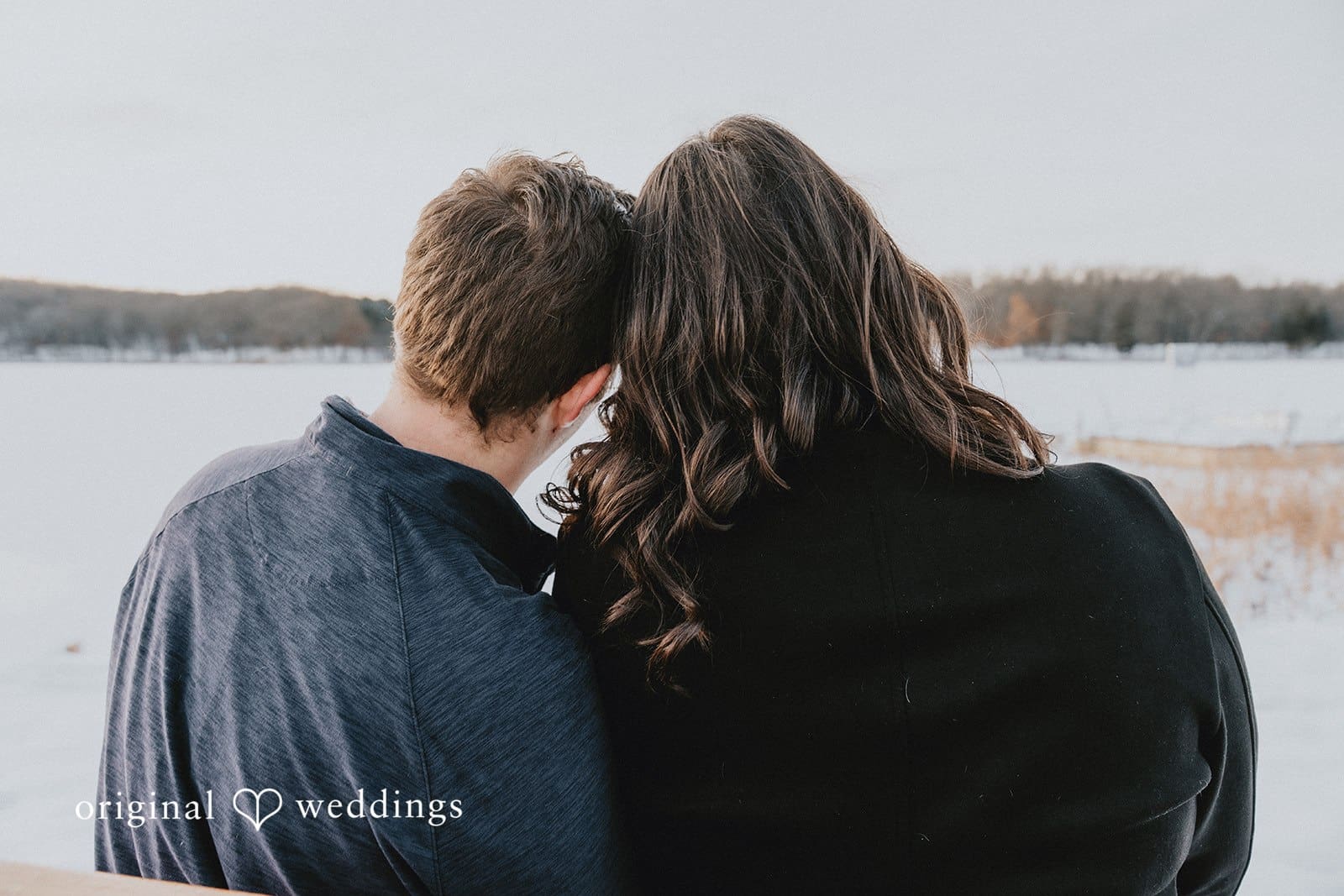 A back-view portrait of the couple overlooking the water