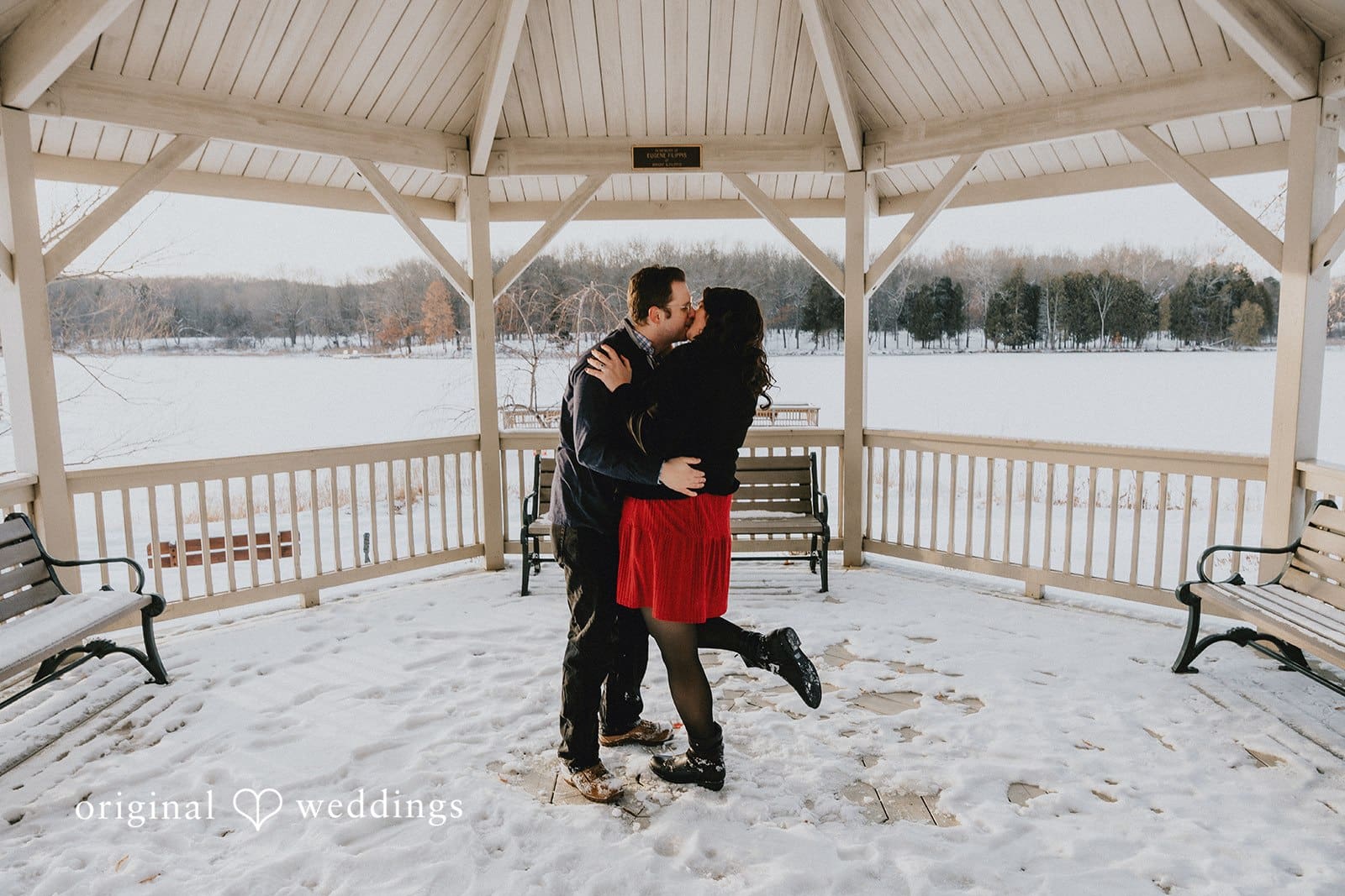 The couple shares a kiss in the snowy outdoor area