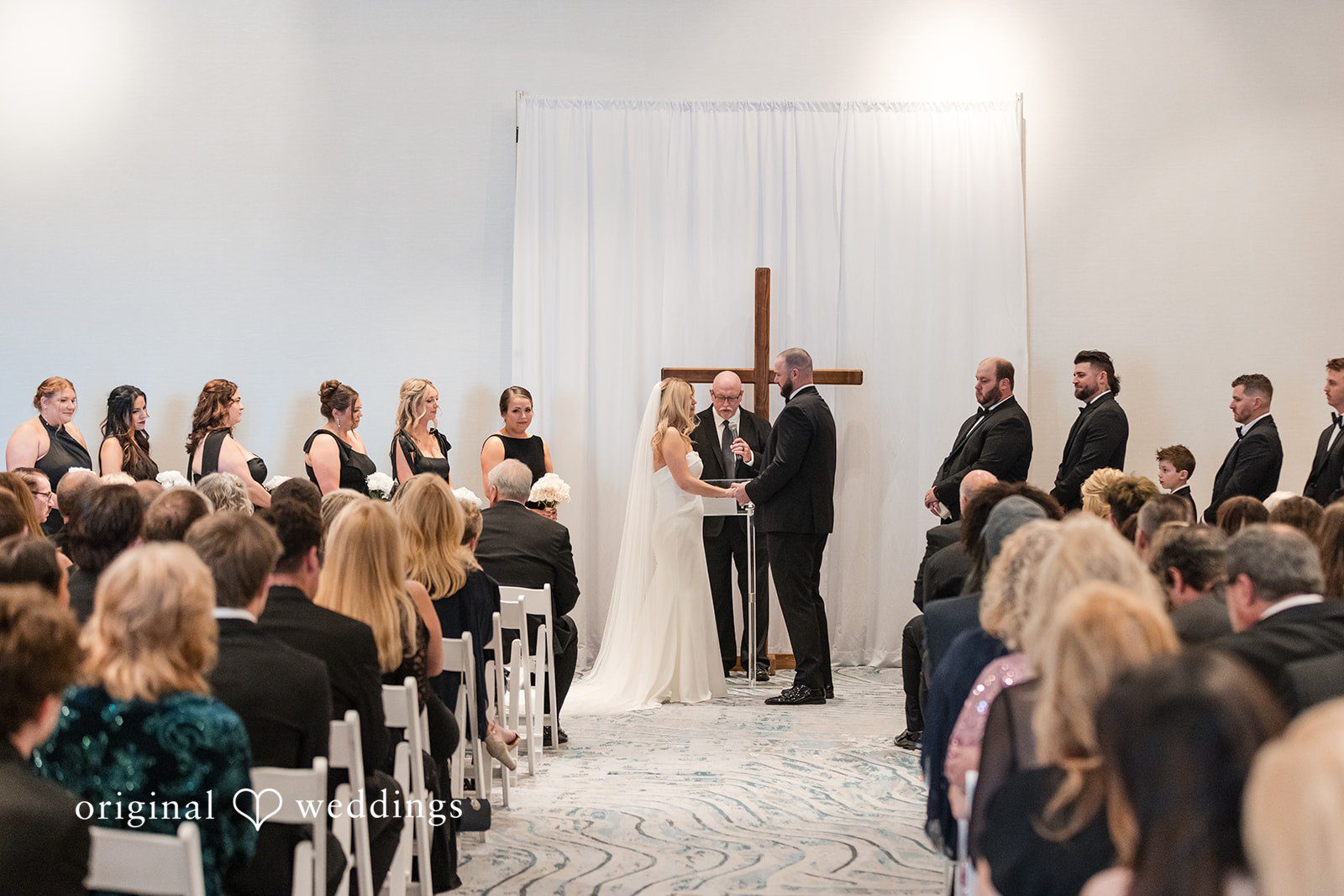 Wedding ceremony with guests seated and couple at the front.