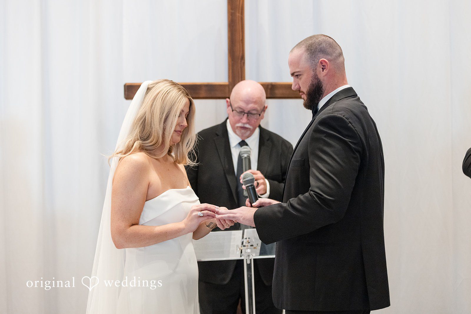 Couple exchanging rings during wedding ceremony.