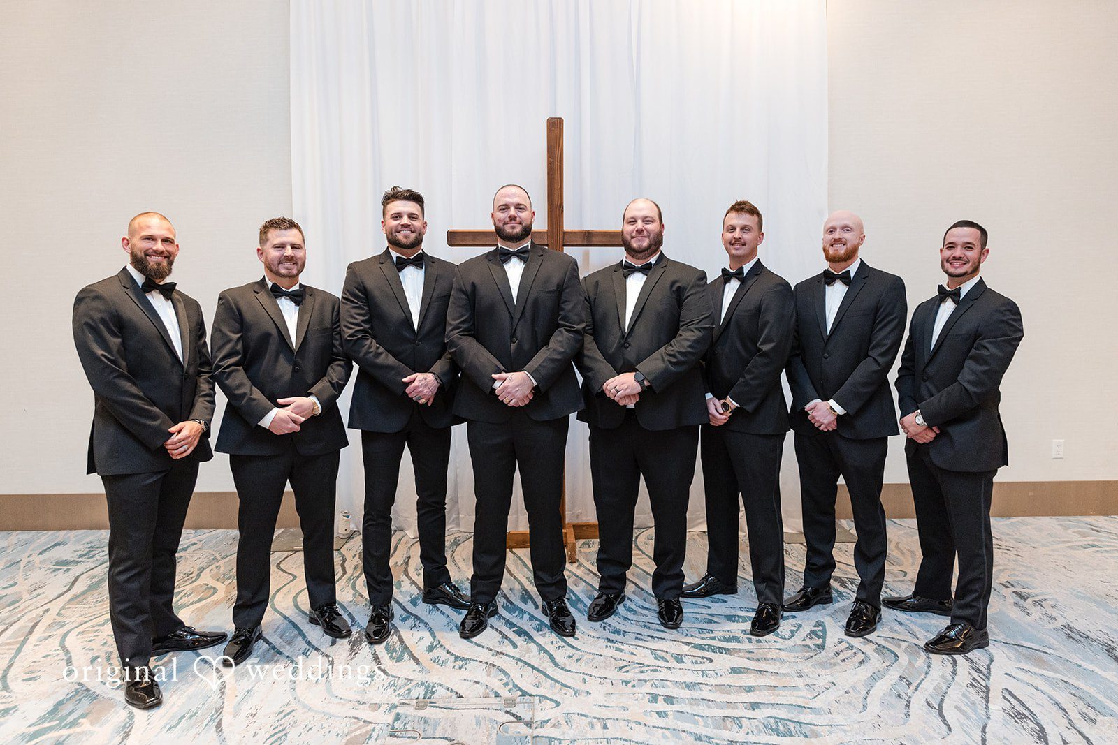 Group of groomsmen standing together in formal suits.