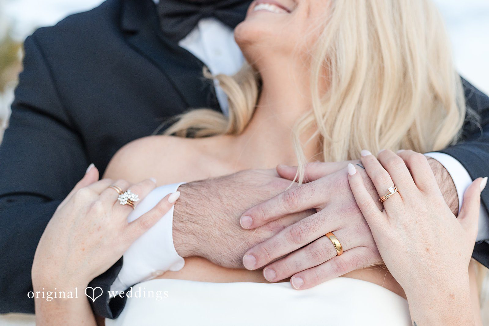 Close-up of couple embracing showing wedding rings.