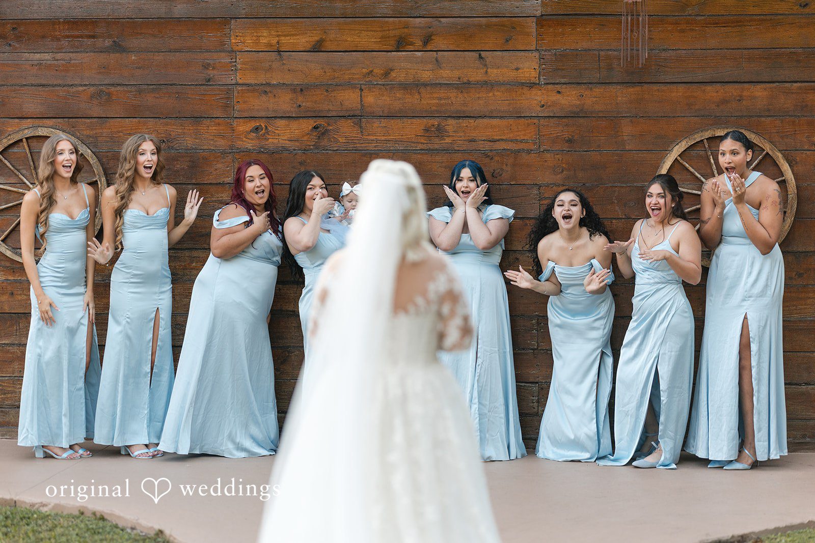 Beautiful bride moving toward bridesmaid at Lovely Barn