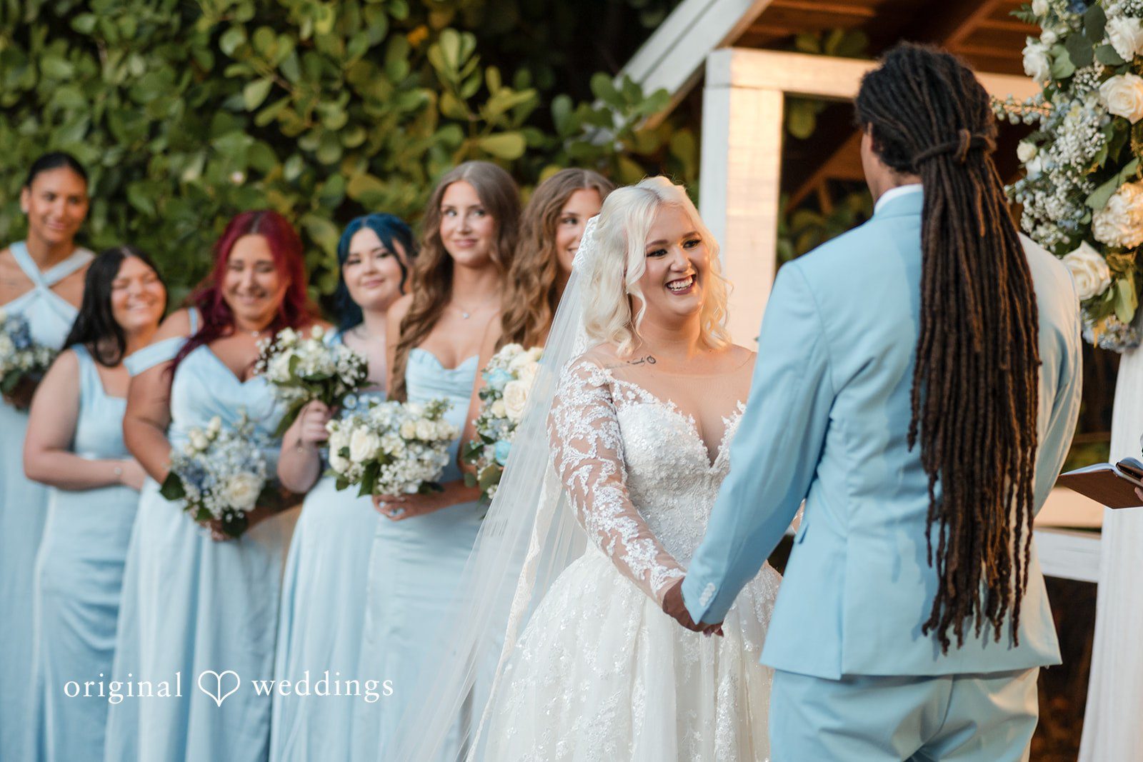 Close-up of bride smiling while holding groom’s hand with back view at Lovely Barn