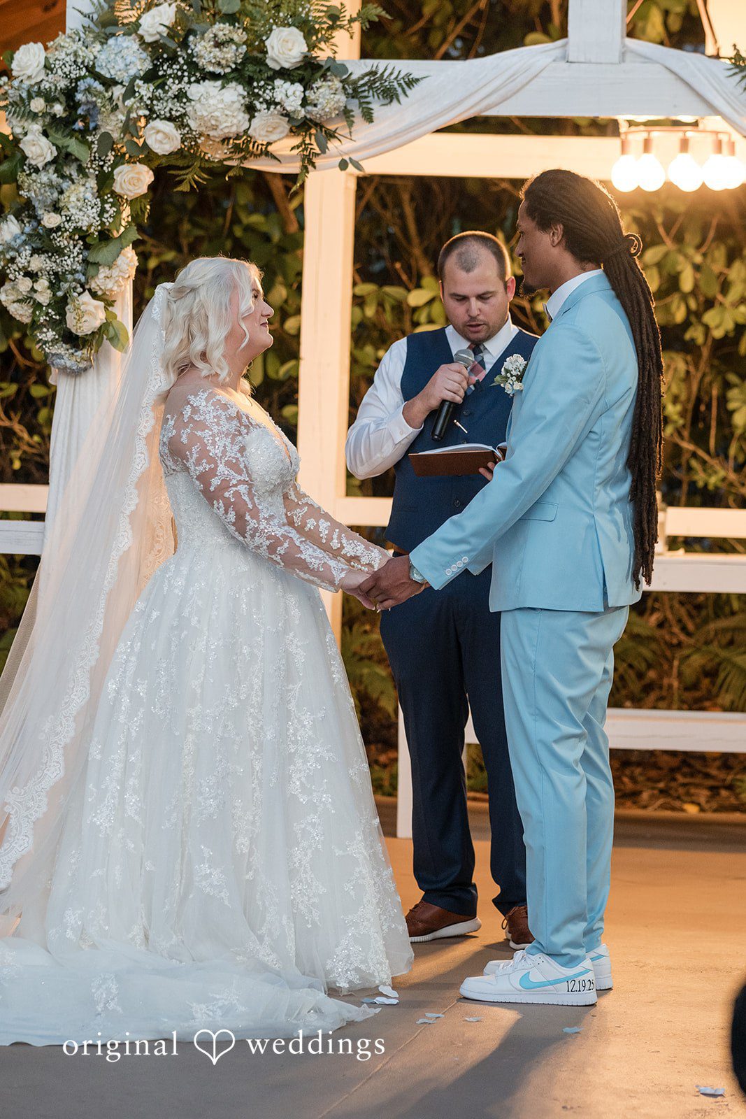 Loving couple standing while priest performs ceremony at Lovely Barn