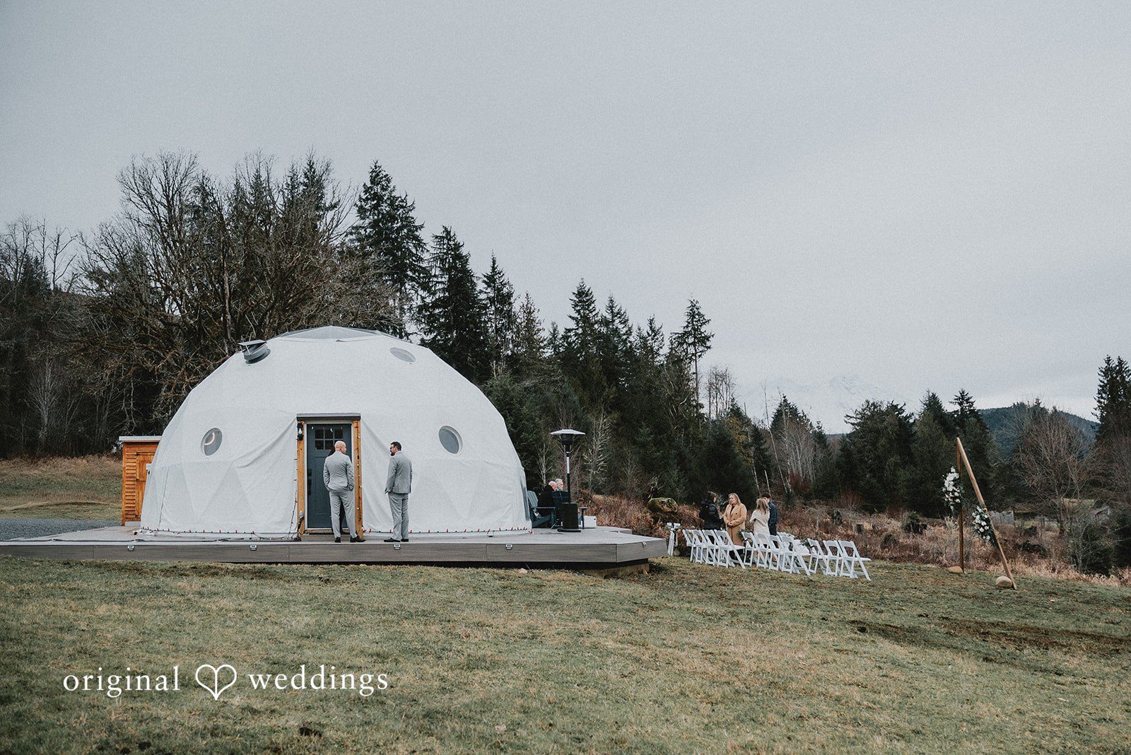 Kelsey + Adam Outdoor wedding venue with white tent structure and mountain background.